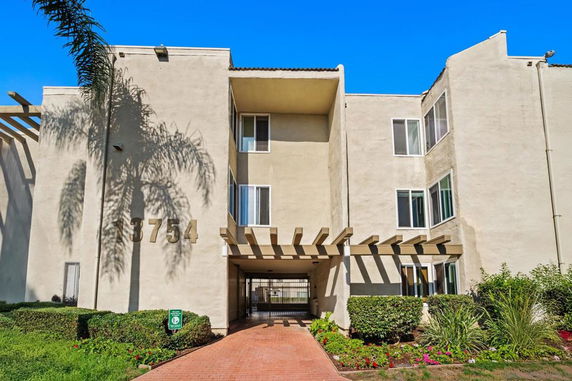 Front view of a multi-story building with a gated entrance.