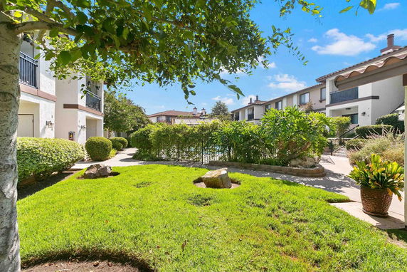 View of apartment buildings with landscaped garden area in the foreground.