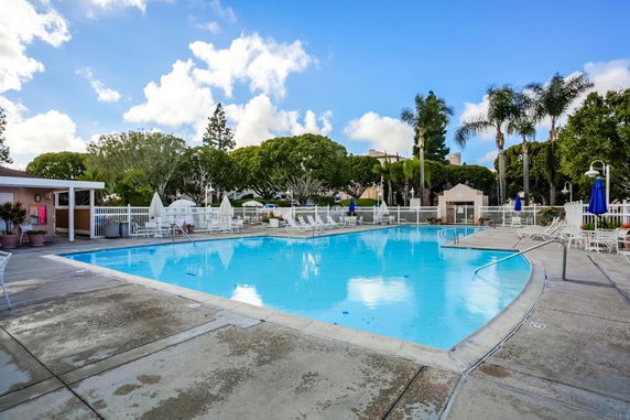 Outdoor swimming pool area with loungers and umbrellas.