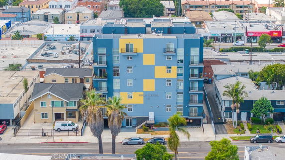 Front view of a multi-story building with a colorful facade in a residential area.