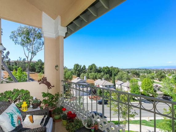 View from a balcony overlooking residential houses and greenery.