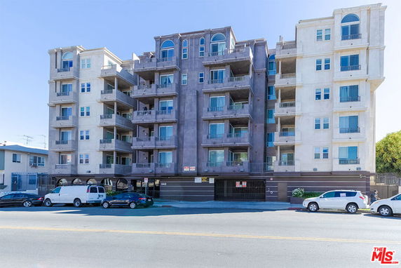 Front view of a multi-story apartment building with balconies.