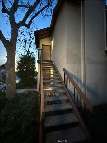 View of an exterior staircase leading to a door on the side of a building.