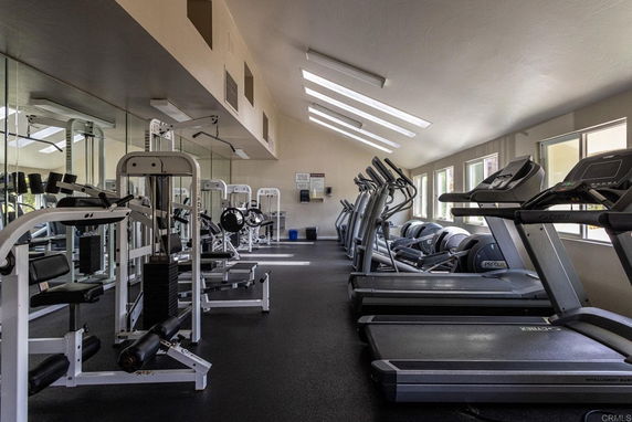 Indoor gym area equipped with treadmills and weight machines.