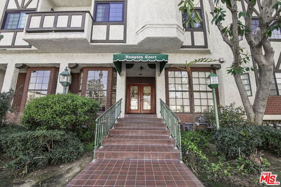 Front view of a townhouse with a brick and stucco exterior and a central entrance.