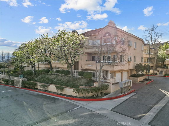 Front view of a multi-story residential building with balconies and garages.
