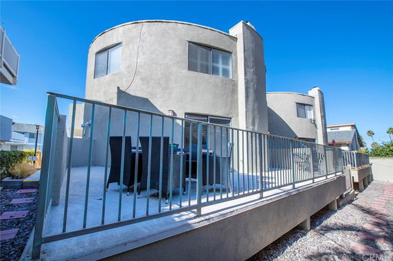 Front view of a modern two-story house with circular design elements and a balcony.