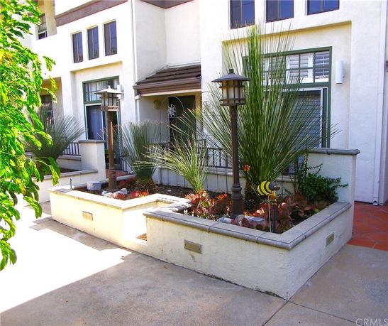 Front view of a house with large windows and a small garden area.
