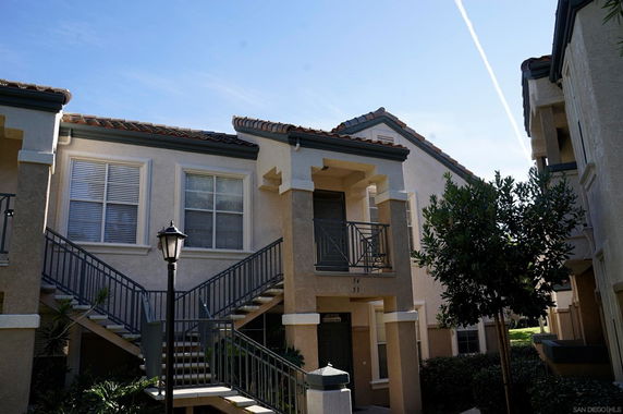 Front view of a multi-story apartment building with exterior stairs and balconies.