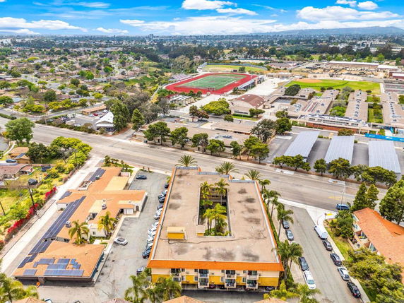 Panoramic view of an area with buildings, roads, and a sports field.