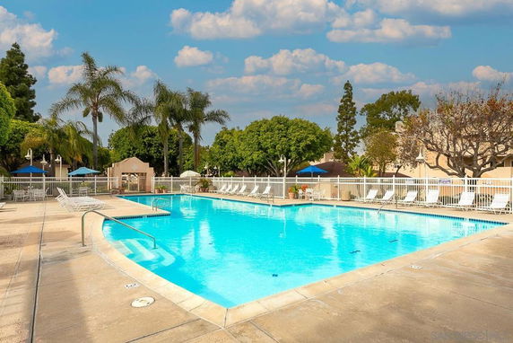 Outdoor swimming pool with deck chairs and umbrellas.