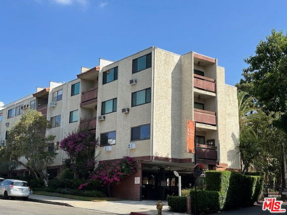 Front view of a multi-story apartment building with balconies.