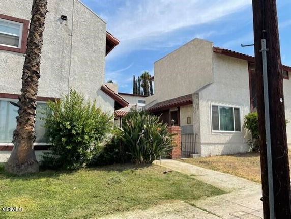 Front view of a two-story house with a concrete pathway.