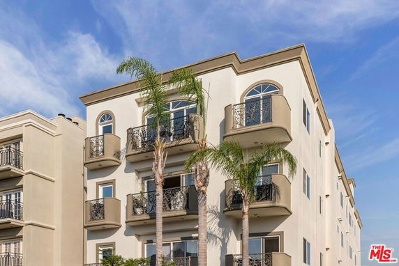 Front view of a multi-story residential building with balconies.
