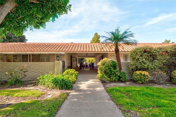 Front view of a single-story house with a tiled roof and a walkway leading to the entrance.