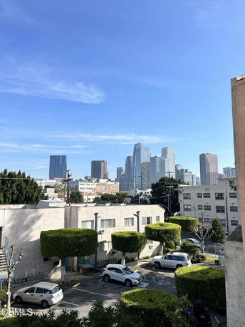View of cityscape and urban skyline from above parking area.
