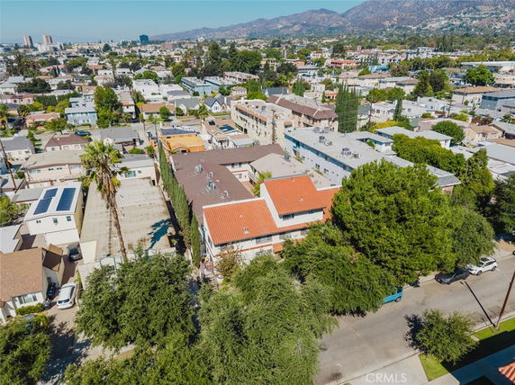 Panoramic view of a cityscape with buildings and distant hills.