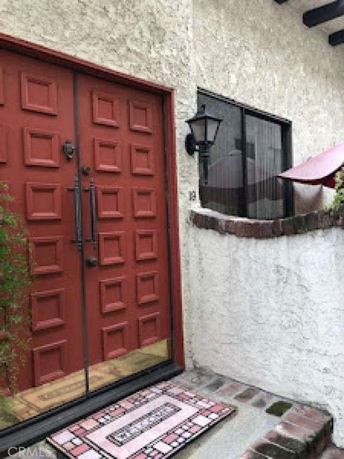 Front view of a house with a red door and textured exterior walls.