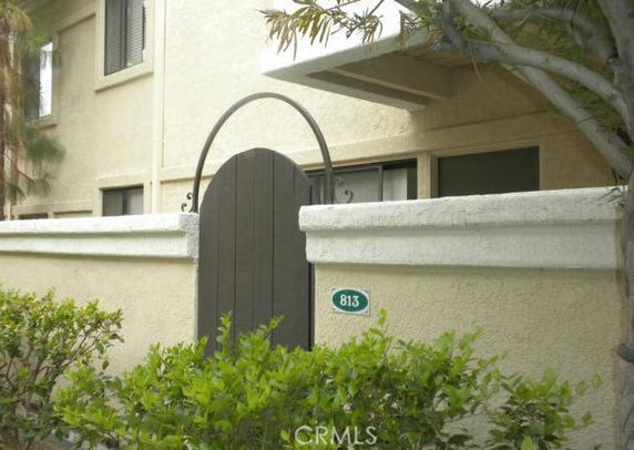 Front view of a building with a dark entrance gate and beige walls.