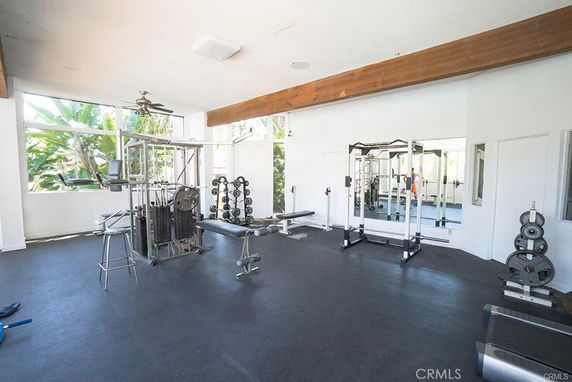 Room with gym equipment and large windows.