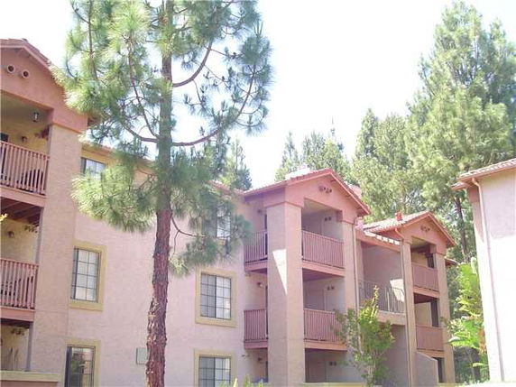 Front view of a multi-story apartment building with wooden balconies.