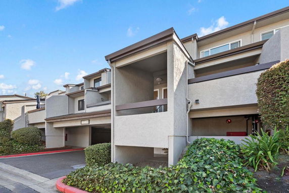 Front view of a multi-story residential building with covered parking.