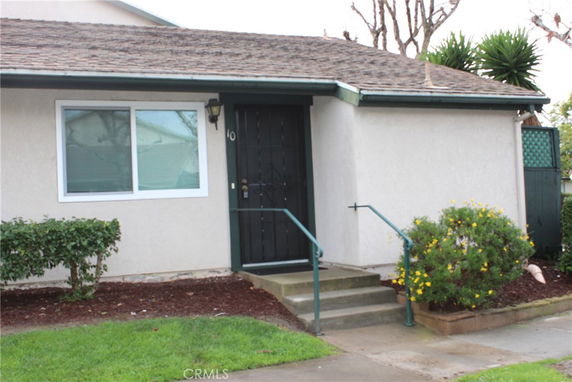 Front view of a single-story house with a dark door and window.