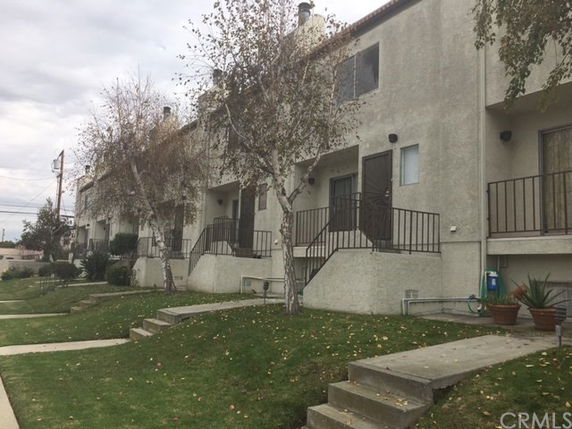 Front view of a two-story townhouse complex with exterior staircases.
