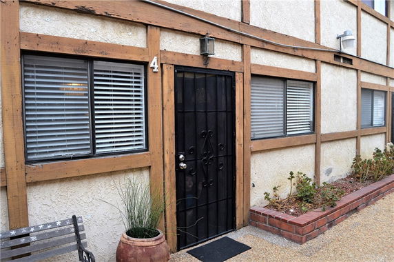 Front view of a building with a black metal door and horizontal wooden trim.
