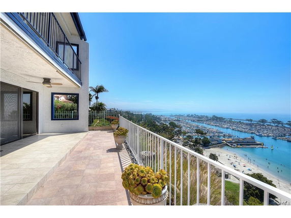 Panoramic view from a balcony overlooking a marina and coastline.