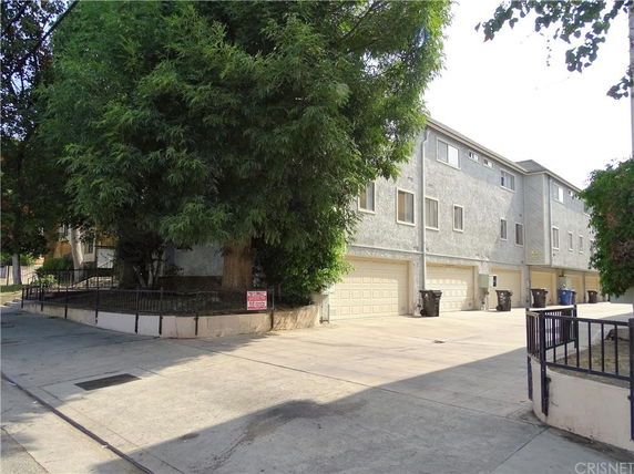 Front view of a multi-story residential building with multiple garage doors.