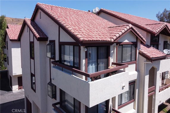 Front view of a multi-story building with red tiled roof and multiple balconies.