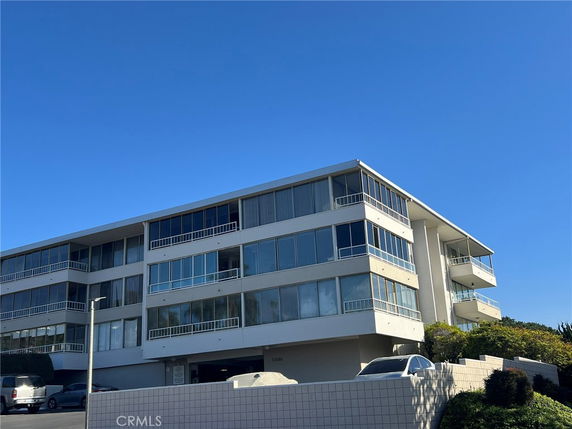 Front view of a multi-story building with large windows and balconies.