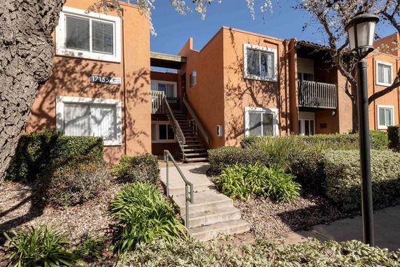 Front view of a two-story apartment building with an exterior staircase.