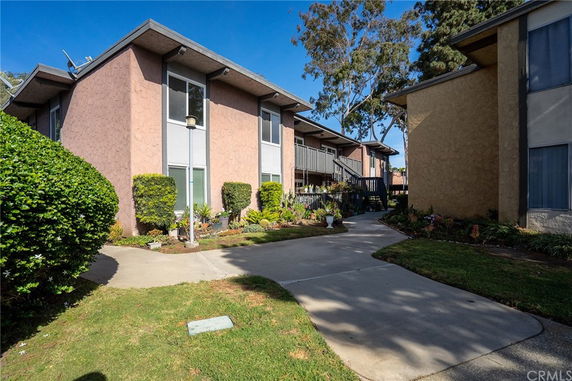 Front view of a two-story residential building with a walkway.