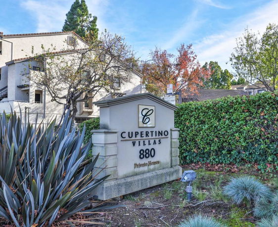 Front view of a multi-story villa complex with a prominent sign displaying Cupertino Villas.