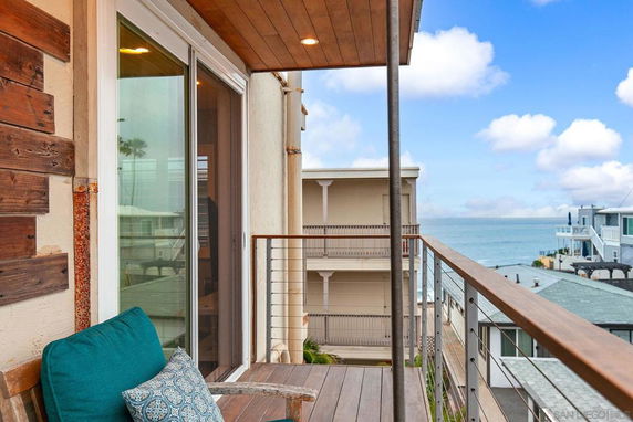 Balcony view overlooking nearby buildings and the ocean.