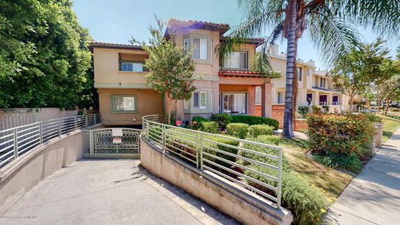 Front view of a two-story house with a gated driveway entrance.