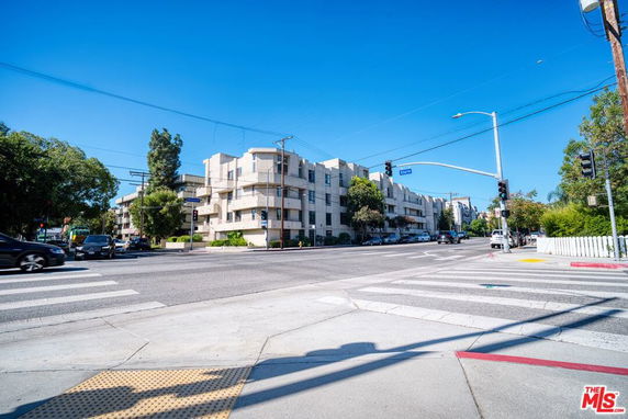 Front view of a multi-story apartment building on a street corner.