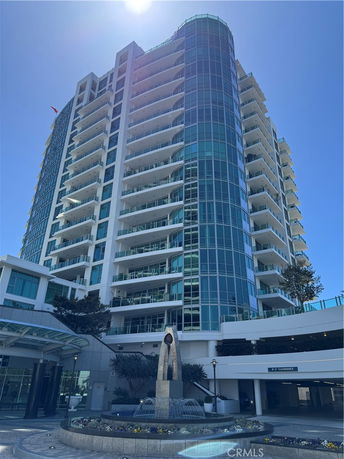 Front view of a high-rise building with glass balconies and modern design.