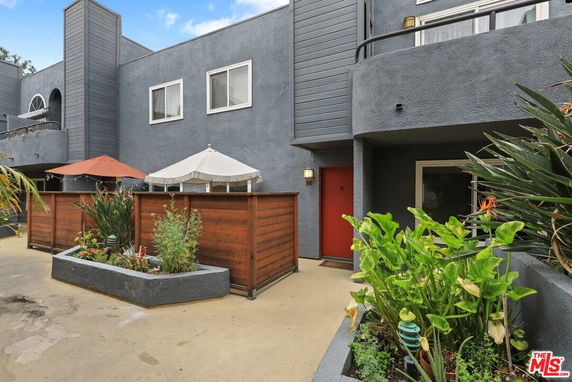 Front view of a two-story house with a balcony and wooden fence.