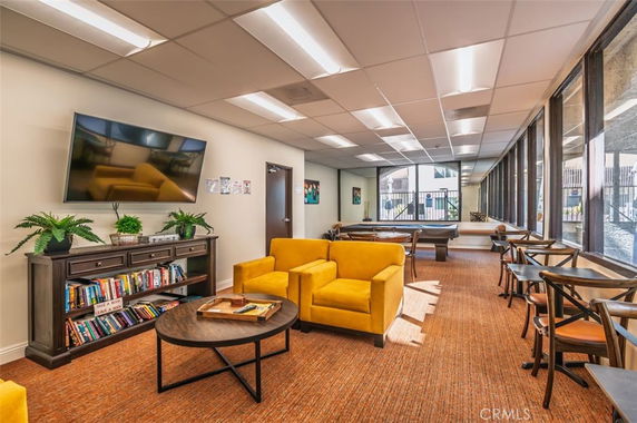 Indoor recreation area with seating, a television, and bookshelves.