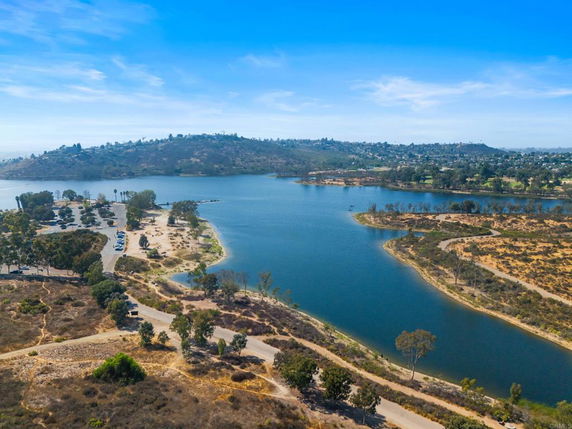 Panoramic view of a lake surrounded by hills and greenery.