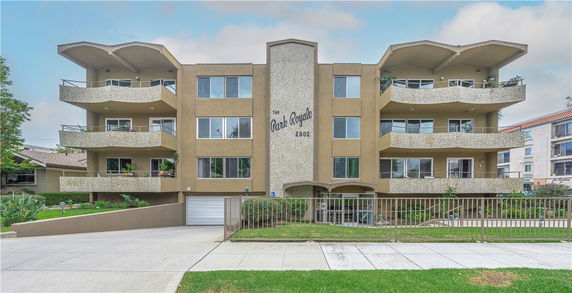 Front view of a multi-story apartment building with balconies.