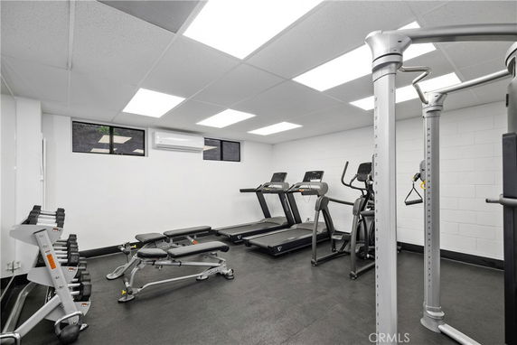 Indoor gym with exercise equipment including treadmills and weights.