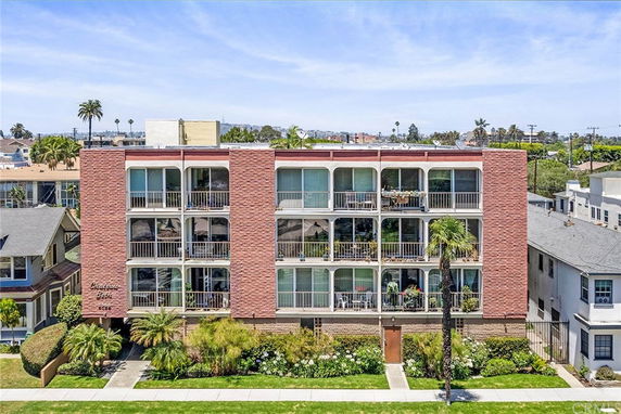 Front view of a multi-story apartment building with balconies.