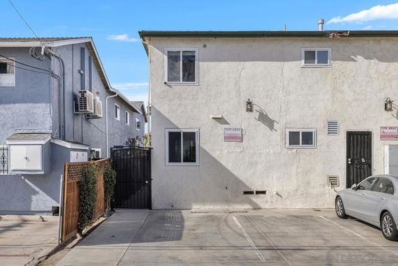Outdoor parking area in front of a two-story residential building.