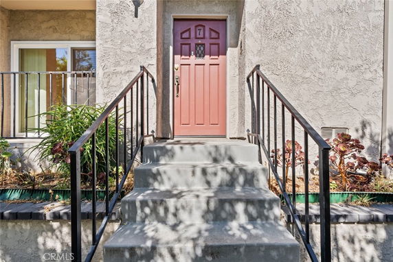 Front entrance of a house with a red door and stairs leading up.