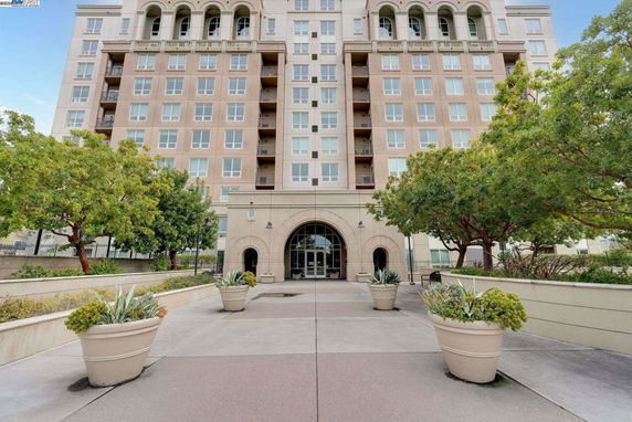 Front view of a multi-story residential building with a central entrance and symmetrical windows.