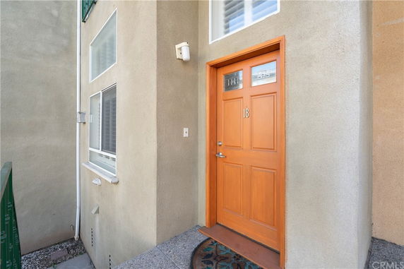 Front view of a house entrance with a brown door labeled number 18.